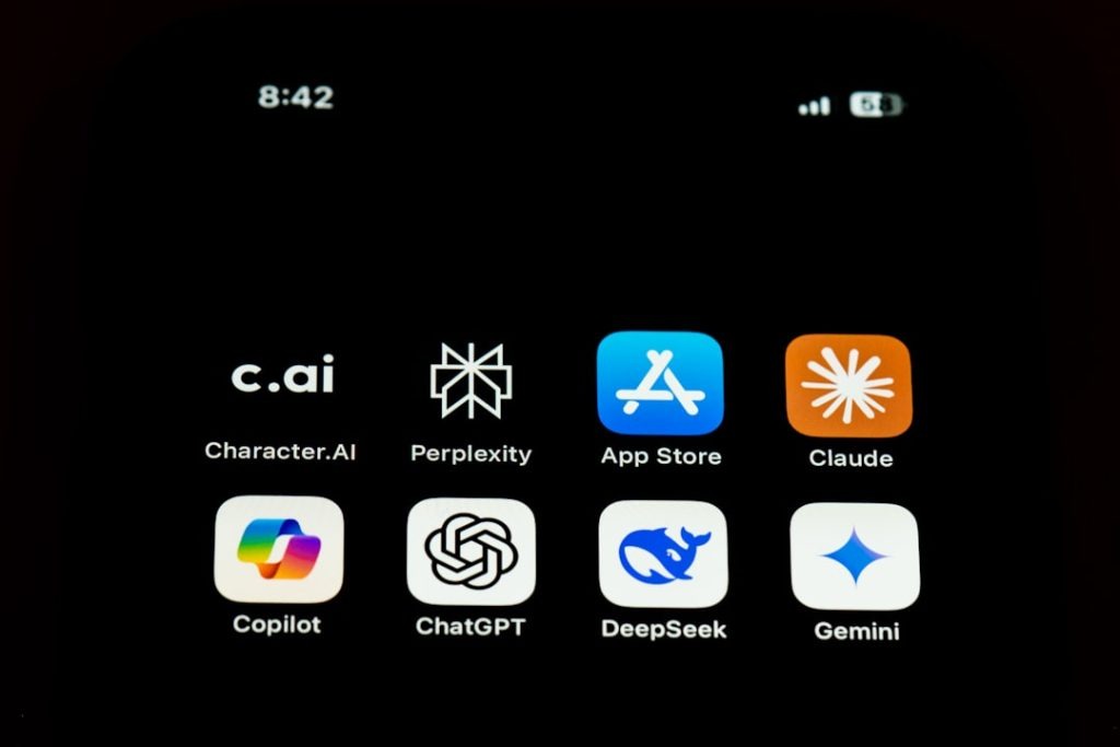 a-close-up-of-a-cell-phone-with-icons-on-it-gepncilzq7c All famous AI chat apps like Character.AI, Perplexity, Claude, Copilot, Chat GPT, Deepseek, Gemini with Appstore icon on an iphone screen.
